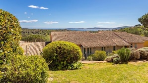 A villa with a tiled roof, surrounded by lush greenery and a clear view of the landscape. - Les Restanques Golfe Saint Tropez by Interhome (Grimaud)