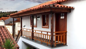 A two-story building with a balcony, wooden railings, and a tiled roof. - Casa da Eira - Turismo Rural (Lousa)