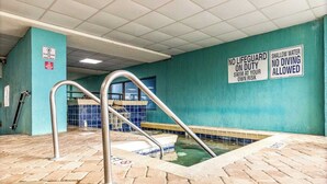 An indoor swimming pool with a no lifeguard on duty sign, shallow water warning, and a no diving allowed sign. - Ideal Oceanview Studio Getaway! Amenities Galore (Myrtle Beach)