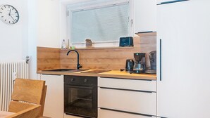A compact kitchen with a built-in oven, a sink, and a window above the countertop. - Apartment Sepp by Interhome (Bad Hofgastein)