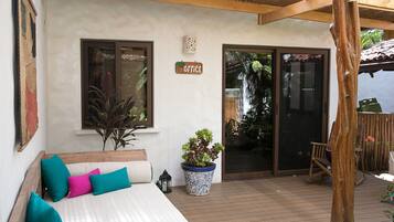 A cozy bedroom with a bed, a potted plant, and a wooden chair.