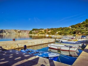 A marina with several boats docked, a clear blue sky, and a hilly landscape in the background. - Apartment Škroćo by Interhome (Maslenica)