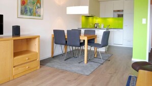 A modern apartment with a dining area, kitchen, and living space. - Allod Park Haus C 604 by Interhome (Davos)