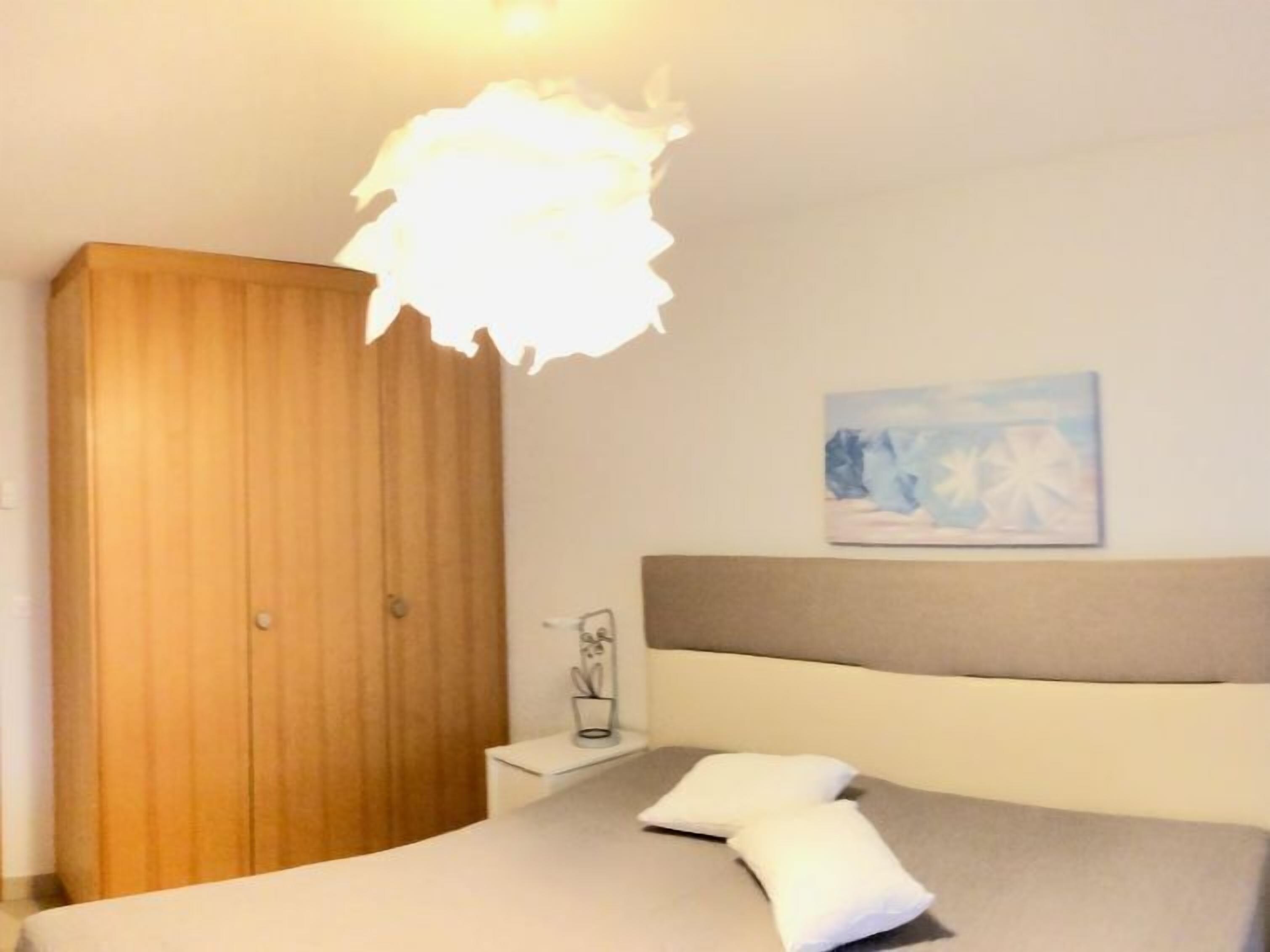 Una camera da letto con un letto, un comodino e un'armadio in legno.