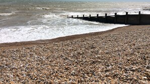 A rocky beach with waves crashing against a wooden sea wall. - The Coast House B&B (Bognor Regis)