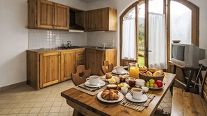Une cuisine avec des meubles en bois, un dosseret carrelé et un coin repas où l'on peut prendre le petit-déjeuner.