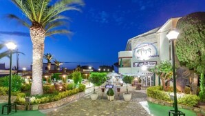 A restaurant with outdoor seating, palm trees, and a stone pathway leading to the entrance. - Palmiers I by Interhome (Llançà)