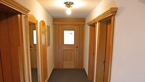 A hallway with wooden doors and a carpeted floor. - Apartment Erika by Interhome (Kappl)