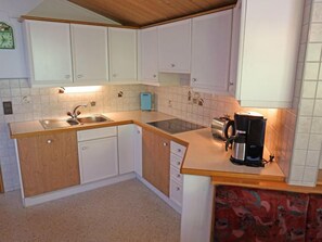 Een koelkast, een vaatwasser, kookgerei, borden en bestek