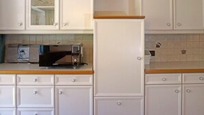 A kitchen with white cabinets, a microwave, and a toaster. - Apartment Erika by Interhome (Kappl)