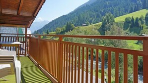 A wooden balcony with a view of a river and mountains. - Apartment Erika by Interhome (Kappl)