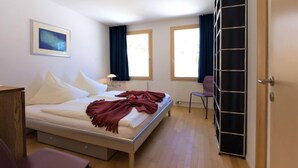 A bedroom with a bed, a chair, a desk, and a wardrobe. - Chesa Lej by Interhome (Pontresina)