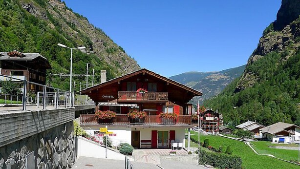 A mountain lodge with a balcony, a stone wall, and a view of the valley. - Christl by Interhome (Stalden)