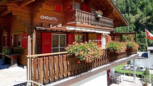 A wooden chalet with a balcony, red shutters, and a sign that reads "CHRISTL". - Christl by Interhome (Stalden)