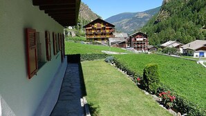 A mountain resort with a view of a chalet-style building, a well-maintained lawn, and a clear sky. - Christl by Interhome (Stalden)