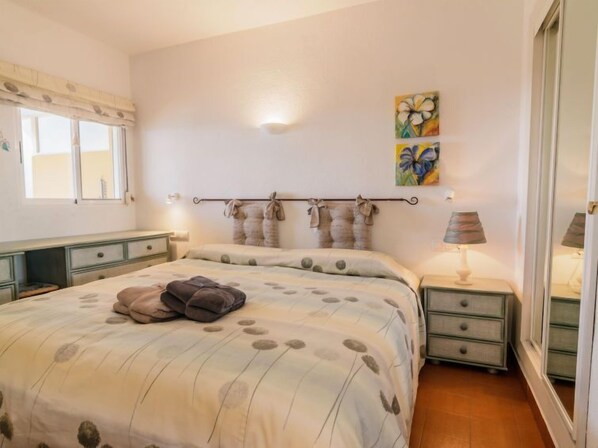 Una camera da letto con un letto, comodini, una lampada e opere d'arte alle pareti.