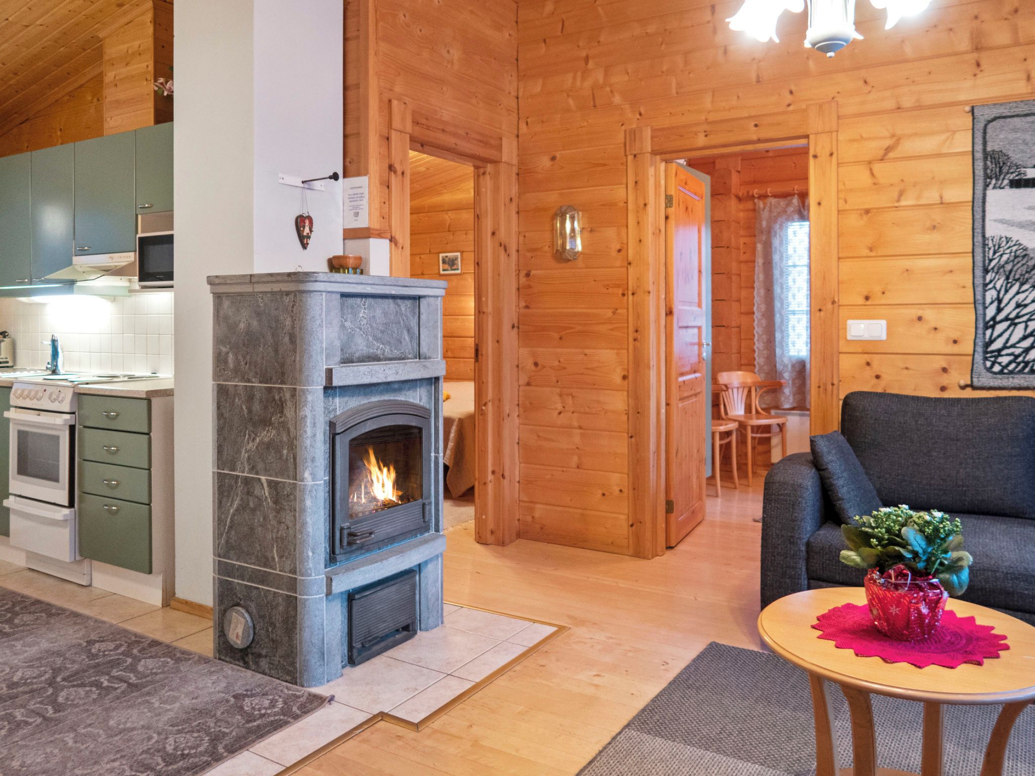 Una sala de estar acogedora con chimenea, comedor y cocina equipada con electrodomésticos modernos.