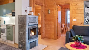 Una sala de estar acogedora con chimenea, comedor y cocina equipada con electrodomésticos modernos.