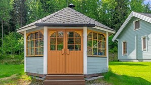 Une petite construction à un seul étage, dotée d’un toit à pignon et d’une porte en bois.