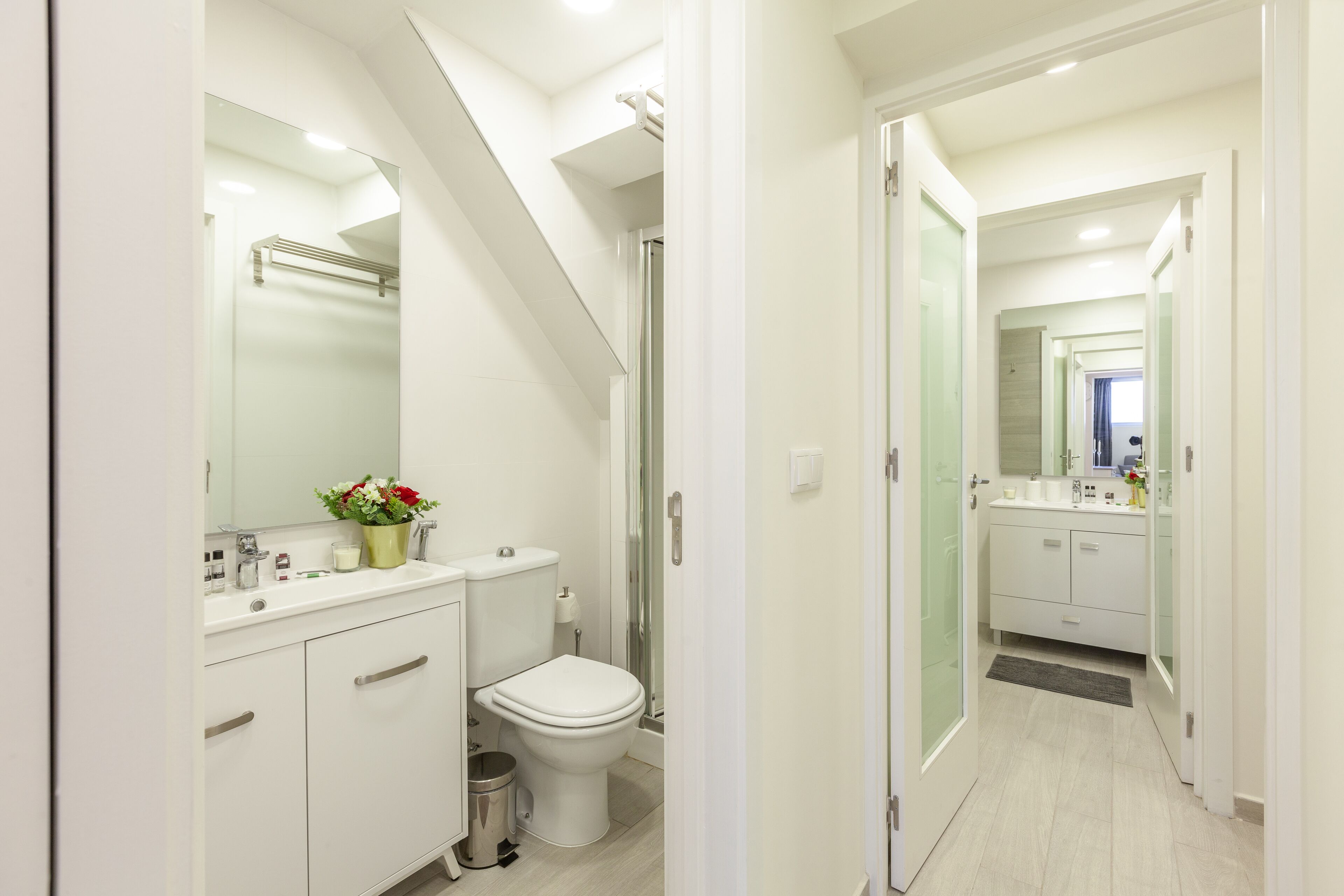 A modern bathroom with a shower, toilet, and sink.