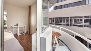 En modern inredning med en balkong, ett vitt skrivbord och ett litet bord.