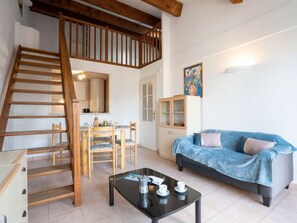 A modern living room with a staircase, a dining area, and a sofa. - Port Quiétude by Interhome (Fréjus)
