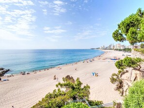 A beach with a clear view of the ocean, sandy shore, and a few people. - Crystal by Interhome (Playa de Aro)