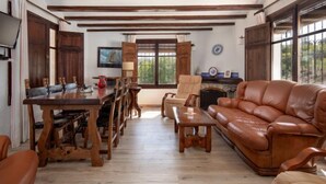 Un salón espacioso con mesa de comedor de madera, sofá de cuero y chimenea.