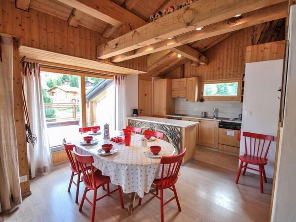 A wooden cabin with a dining area, kitchen, and a view of the outside. - Bisse-Vieux A-4 by Interhome (Nendaz)