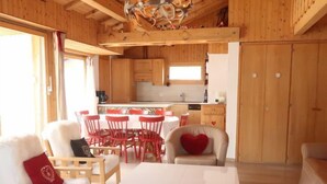 Un interior de madera con comedor, cocina y zona de estar.