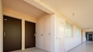 A corridor with three doors, one dark brown and two light pink, leading to individual rooms. - Les Hesperides by Interhome (Cavalaire)
