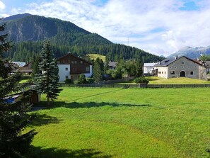 Escape to a serene countryside retreat surrounded by lush greenery and a majestic mountain backdrop.
