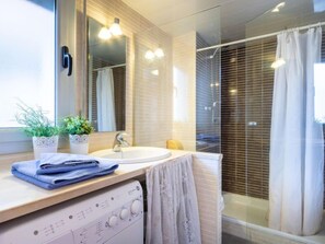 A modern bathroom with a sink, mirror, and shower. - Cap Mestral by Interhome (Roses)