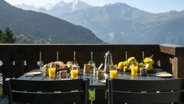 Una tavola apparecchiata per la colazione con vista sulle montagne.