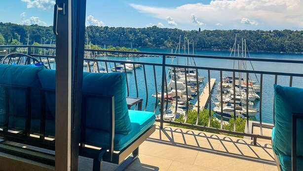 Un balcón con vista a un puerto deportivo y un lago.