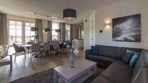 Una sala de estar moderna con un sofá, una mesa de centro y un comedor.