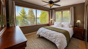 A bedroom with a bed, bedside tables, a desk, and a window with blinds. - Alaska Adventure Awaits: Charming Lakeside Living (Wasilla)