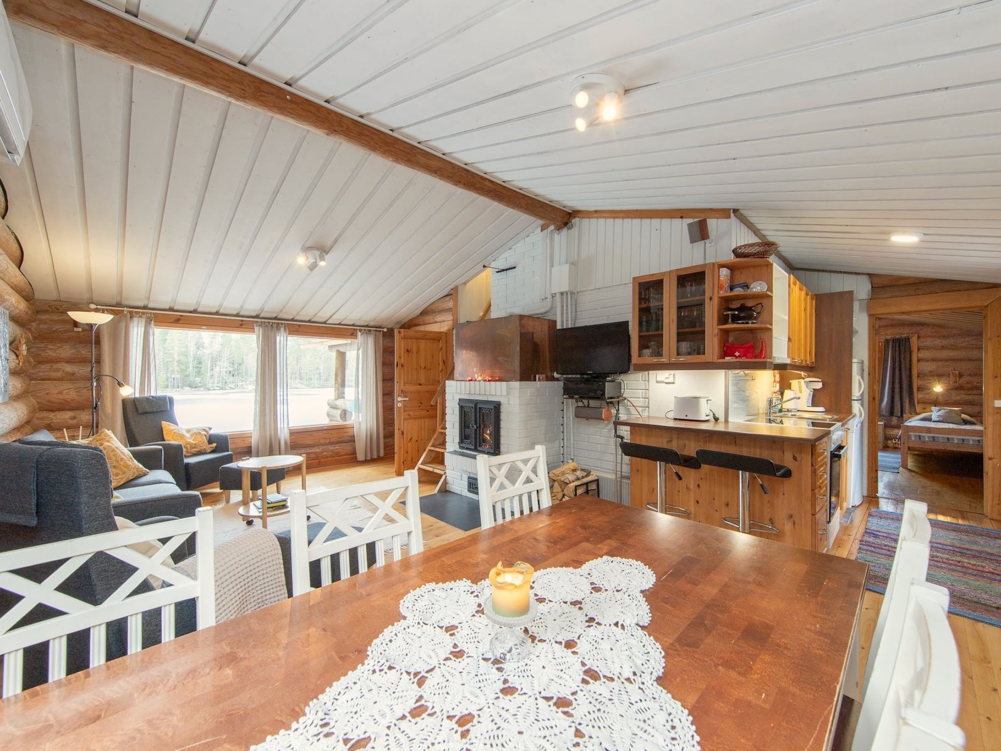 Un intérieur de chalet chaleureux comprenant un coin repas, une cuisine et un espace salon.