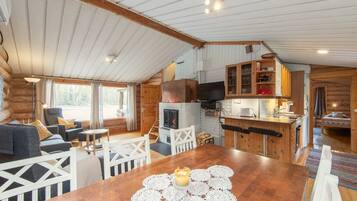 Un intérieur de chalet chaleureux comprenant un coin repas, une cuisine et un espace salon.