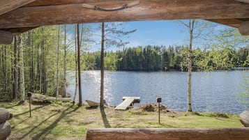 Una cabaña de madera con vista a un lago rodeado de árboles.