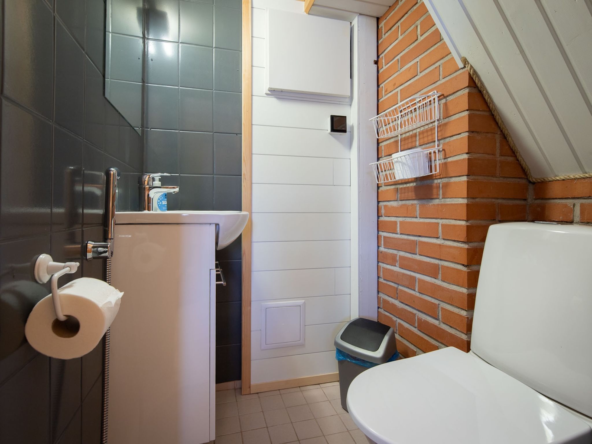 A compact bathroom with a toilet, sink, and shower.