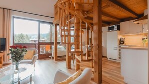 A modern interior with a wooden staircase, a glass dining table, and a kitchen area. - Anna-Katharina by Interhome (Bad Hofgastein)