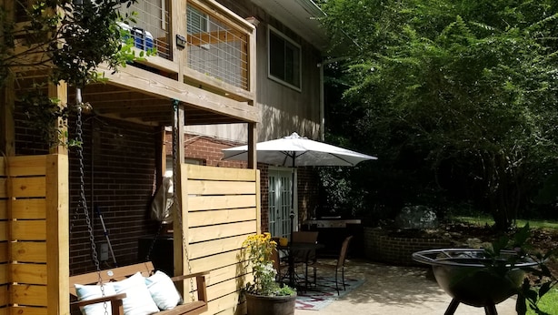 A wooden deck with a swing, a grill, and a patio table with chairs. - Private Basement Apartment (Athens)