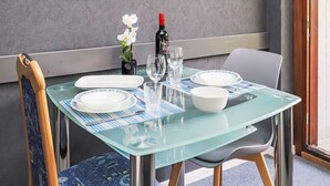 A dining table with plates, glasses, and a bottle, set against a textured wall with a small potted plant. - Rosablanche B22 by Interhome (Siviez-Nendaz)