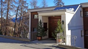 A modern two-story house with a wooden front door, a small porch, and a solar panel on the roof. - Chesa Cripels II by Interhome (St. Moritz)