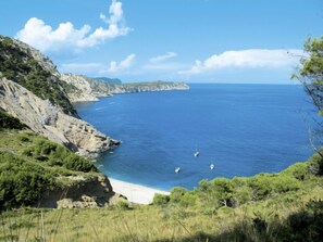 A coastal landscape with a clear sky, a sandy beach, and rocky cliffs. - Villa Lavanda by Interhome (Alcúdia)