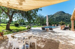 A patio area with a pool, outdoor seating, and a view of a mountain. - Villa Lavanda by Interhome (Alcúdia)