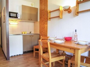 Een koelkast, een microgolfoven, kookgerei, borden en bestek