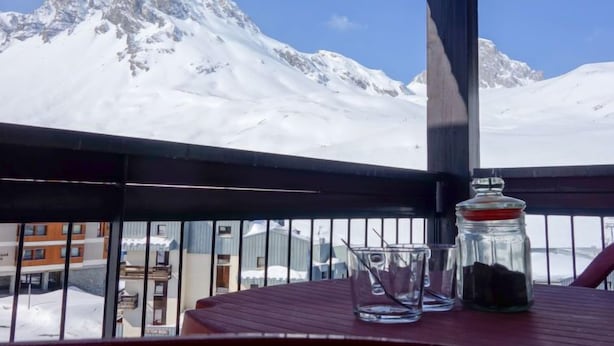 Un balcón con vistas a montañas nevadas.