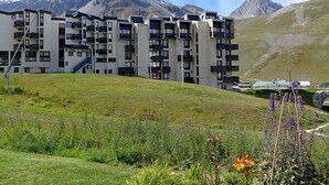 Un hotel de varios pisos con balcones, con montañas al fondo.